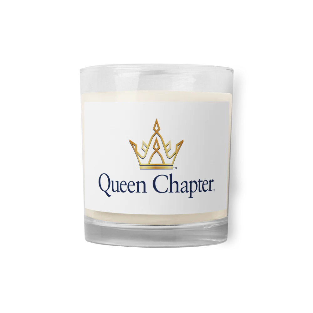 A glass candle with a white label that has the Queen Chapter logo printed on it.