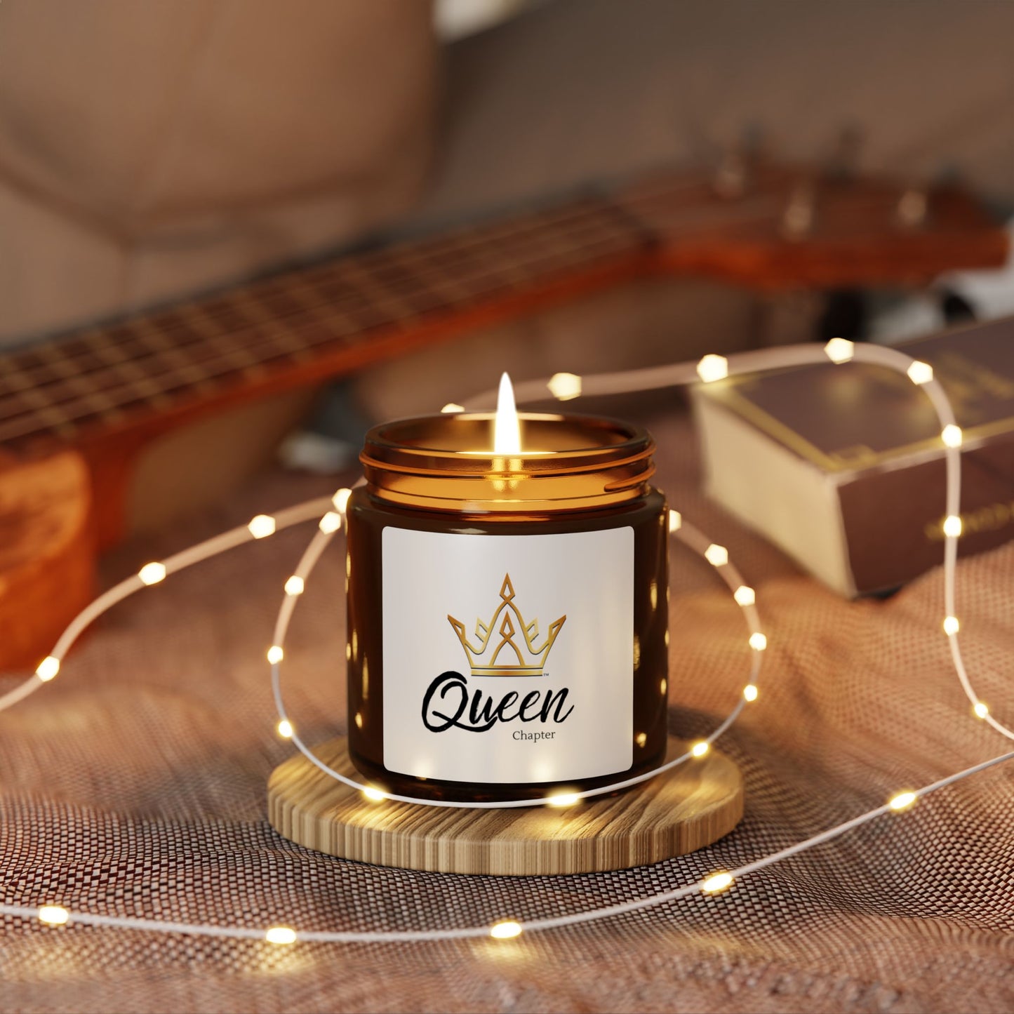 Candle labeled 'Queen' with a guitar in the background