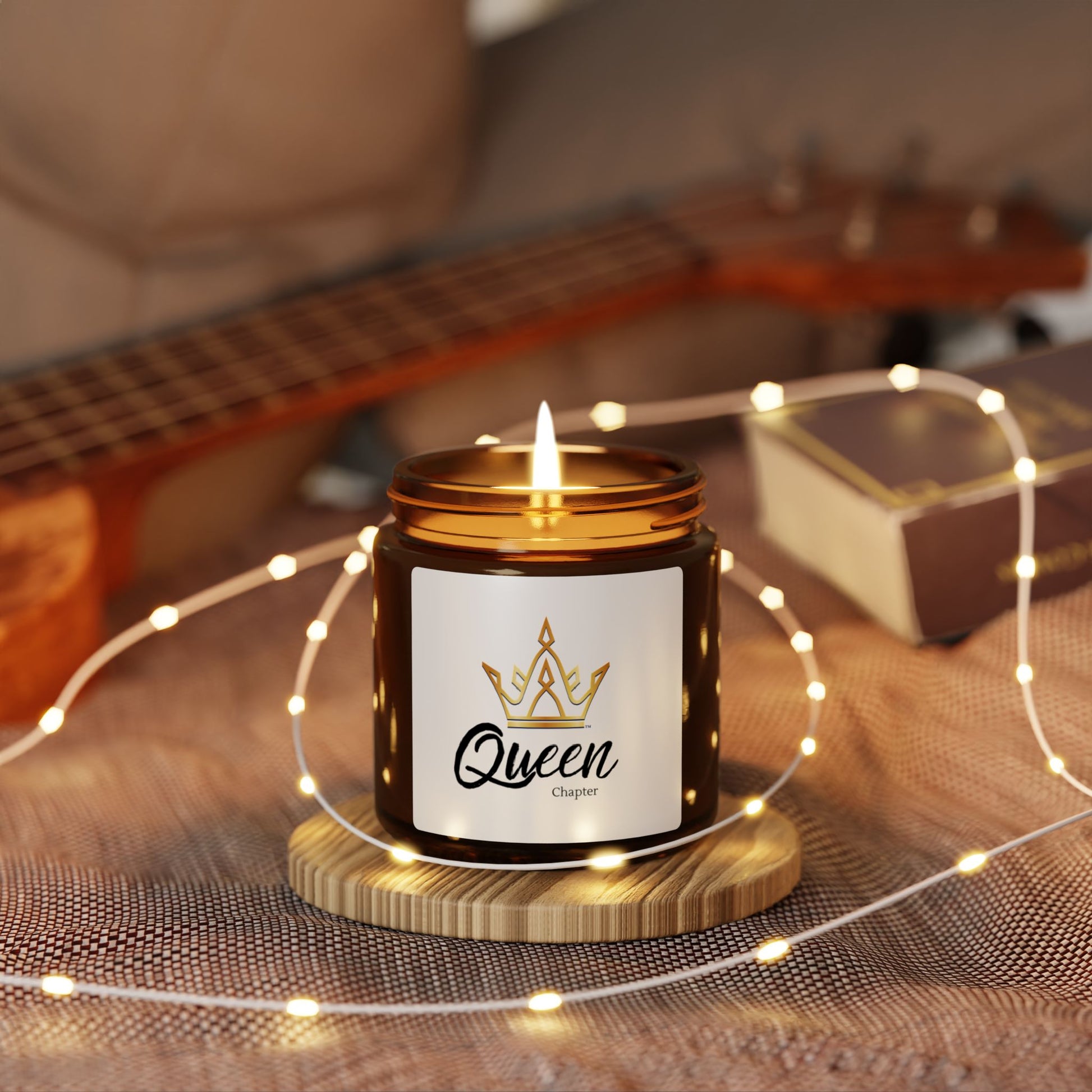 Candle labeled 'Queen' with a guitar in the background