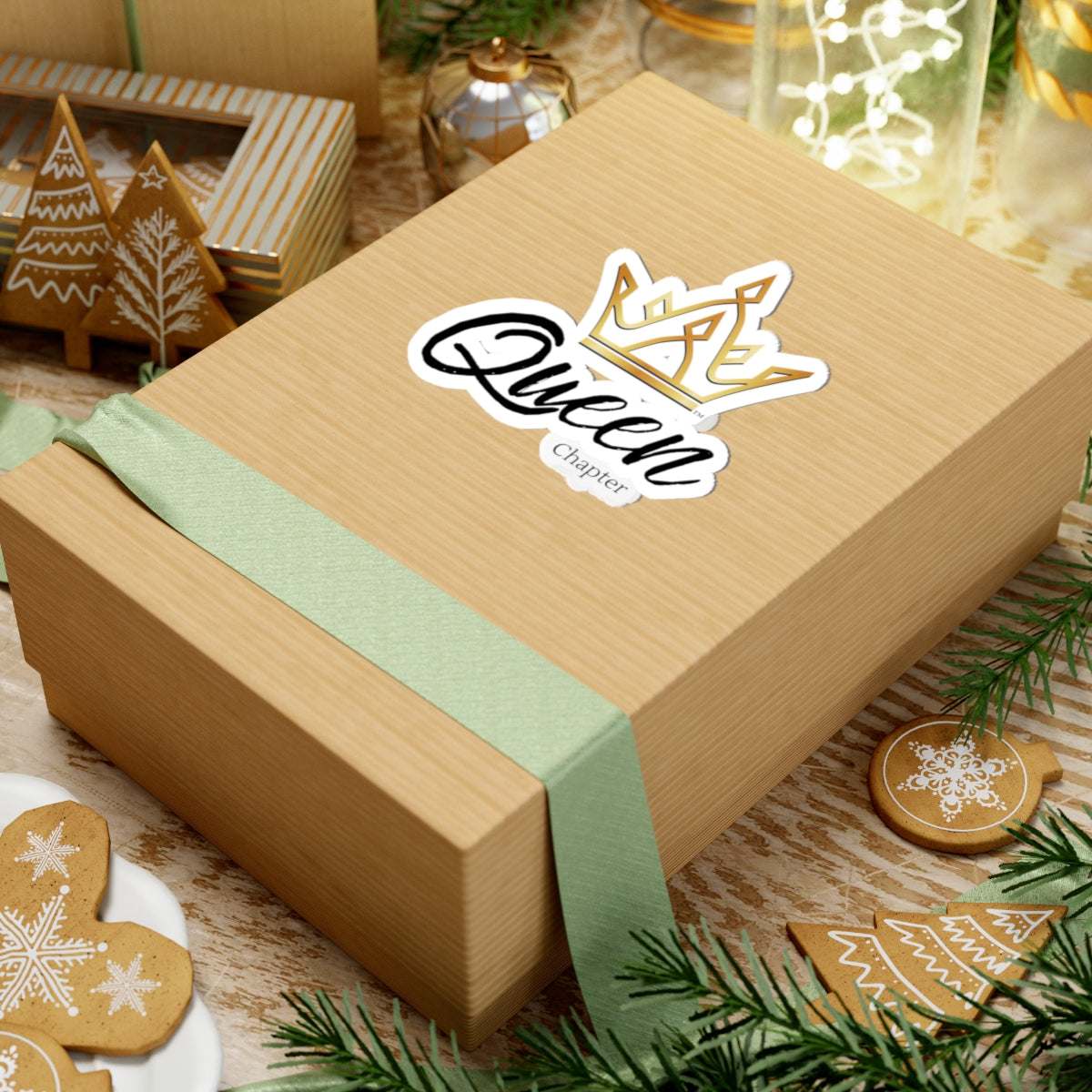Wooden gift box with 'Queen' sticker on a festive background with cookies and decorations